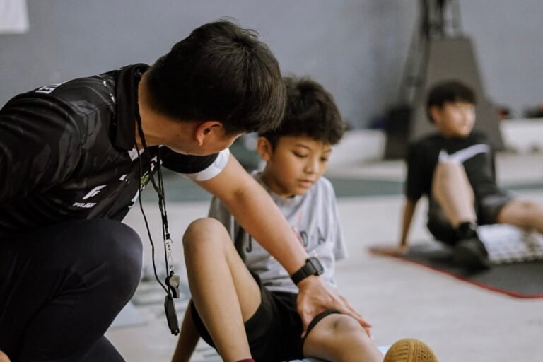 Terapis memasang taping pada kaki atlet muda